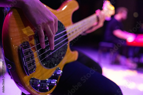 Canvas Print Close-up of a musician hand playing a five-string electric bass guitar during a