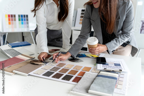 Tableau sur toile Interior Designer Selecting Material Samples and Color Swatches with Client in S