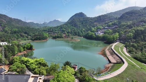 Φωτογραφία Panoramic view of a green reservoir dam surrounded by lush mountains and trees