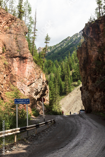 Road and Red cliffs near Red Gates in Ulagan Road in Aktash region. Altai, Siberia, Russia
