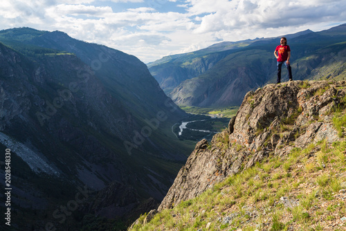 A man standing on the cliff over the valley of Chulyshman river. Altai Republic, Siberia. Russia