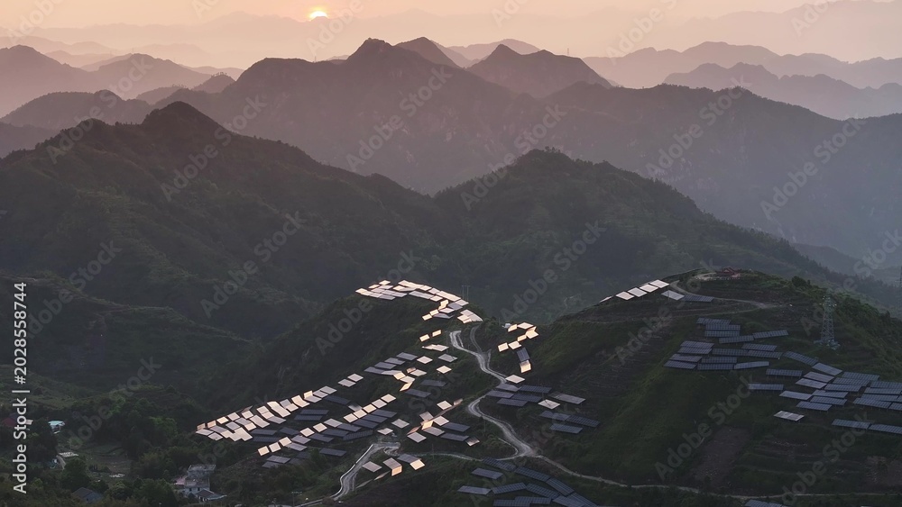 Fototapeta premium Morning mist and sunrise over terraced fields and village in Guizhou mountains