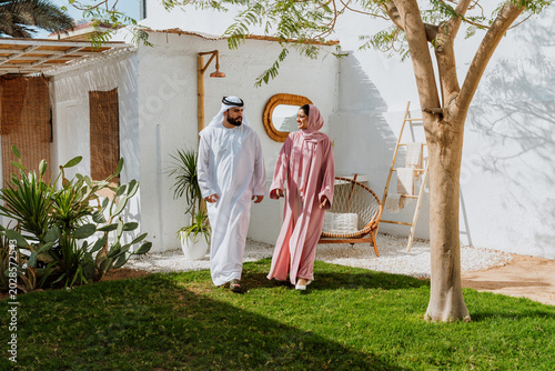 Emirati couple walking through a traditional garden together