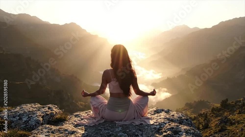 woman meditating at mountain sunrise mindfulness wellness and inner peace concept.