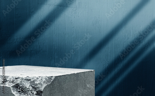 Concrete block podium stage with blue textured wall backdrop and curtain light shadow overlay. Empty stone platform presentation stand for cosmetic luxury product marketing design mockup.