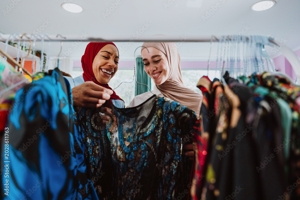 Obraz premium women friends smiling shopping in clothing store