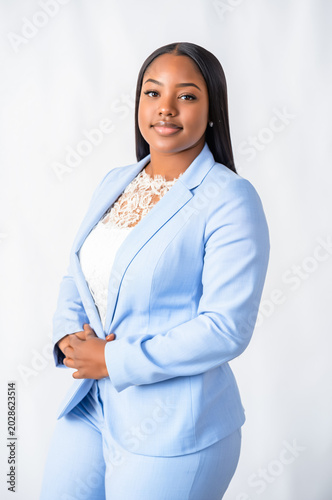 Confident businesswoman in elegant light blue suit smiling on neutral background. Professional corporate fashion and female leadership concept.