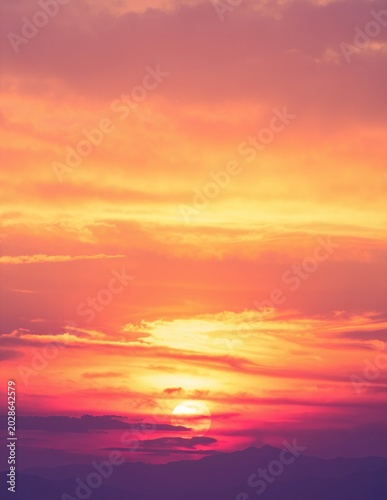 a sunset with the sun setting over the mountains