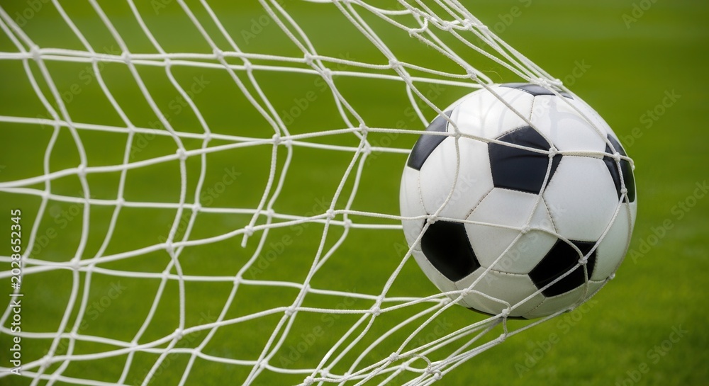 Fototapeta premium Soccer ball flying into goal net