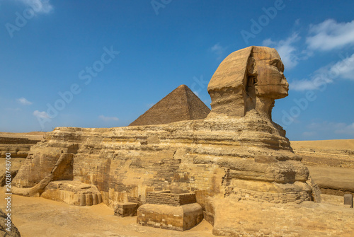 Horizontal view of the Great Sphinx of Giza with a pyramid in the background, Egypt. One of the most iconic ancient monuments, symbol of Egyptian civilization, history and archaeology