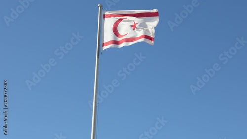 Turkish Republic of Northern Cyprus Flag waving in blue sky. Northern Cyprus.