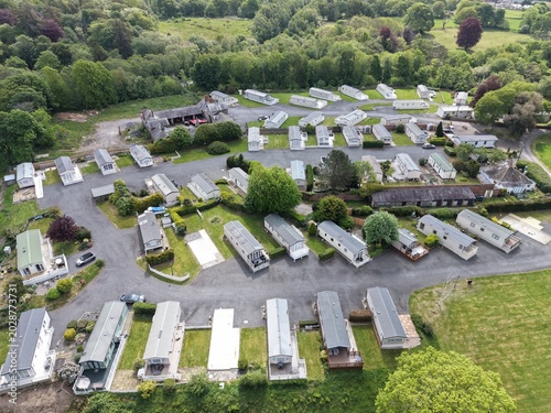 Drone view drifting above caravan park with open sky light and natural green surroundings