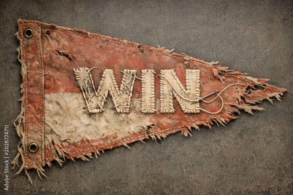 Naklejka premium A piece of cloth with the motivational phrase 'win' printed on it, great for motivational and sports-themed images