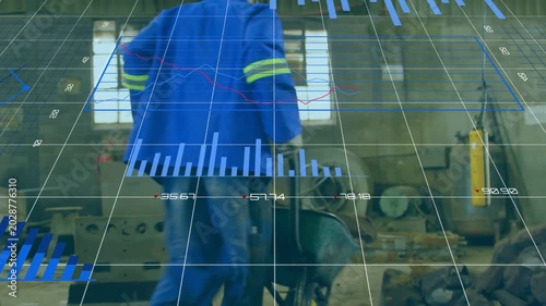 Worker gripping barrow handles moving load in factory, data overlay following barrow showing charts