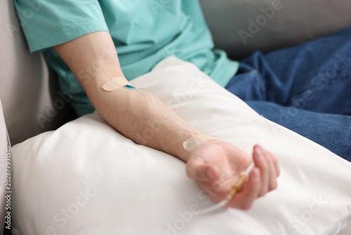 Φωτογραφία Man with IV drip on sofa at home, closeup