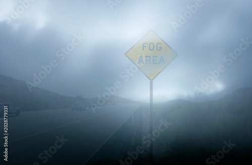 Принти на полотні A yellow diamond shaped traffic sign stating Fog Area in very heavy fog with tra