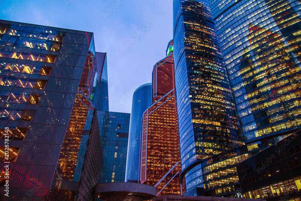 Fototapeta premium Bottom-up view of the skyscrapers of the Moscow City business center. Modern glass office buildings at night.