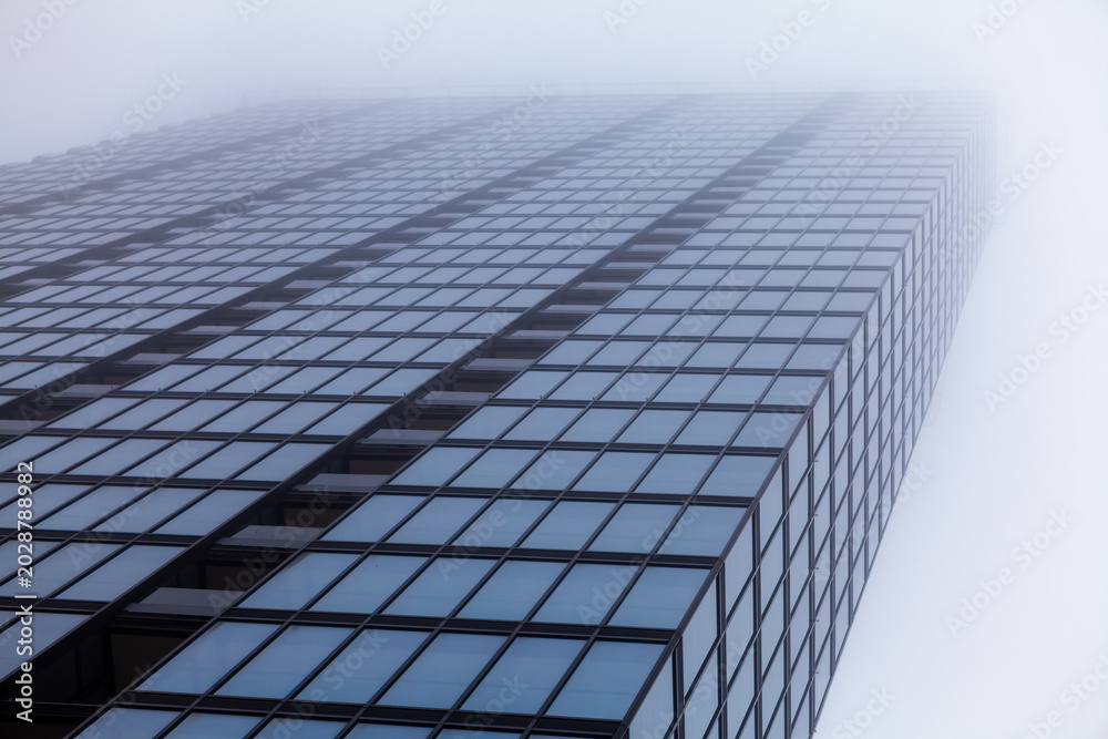 Fototapeta premium Glass skyscraper fading into fog