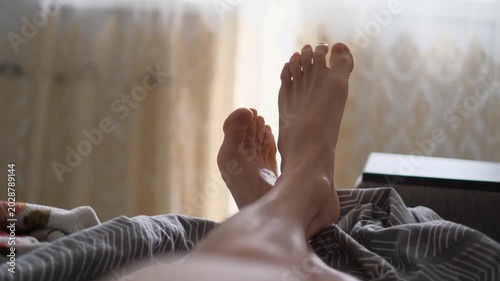 Close-up of a loafer's male legs on an unmade bed