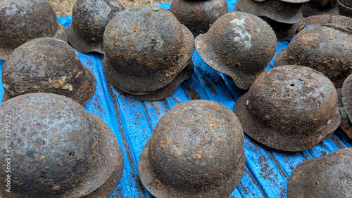 Bild auf Leinwand Heavily rusted World War II steel helmets as archaeological ground finds with visible corrosion