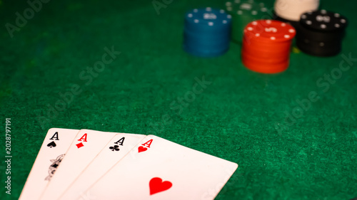 Foto Four aces playing cards with colorful poker chips on green felt table background