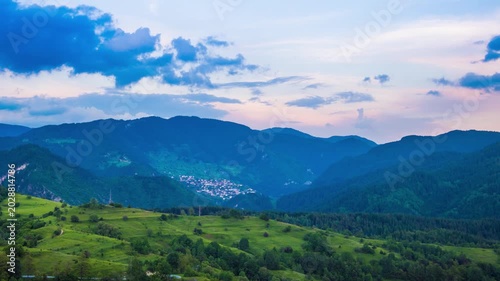 Multicolored sky with clouds and sunset light over the Rhodope Mountains with a intermountain village