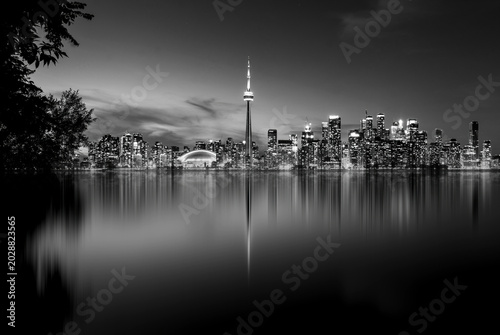 Toronto skyline at night with CN Tower and reflections in the water