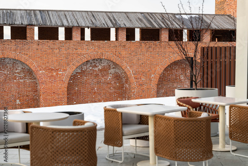 Quadro su tela Rooftop Terrace Dining With Brick Arches, White Tables And Rattan Chairs Along S