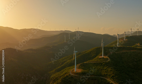 Foto Wind turbines on rolling hills at sunset capture clean, renewable wind energy, f