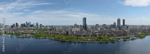 Panoramic aerial drone view of Boston Back Bay skyline, Prudential Tower, and Charles River Esplanade on a clear summer day, featuring historic brownstones and city skyscrapers, USA.