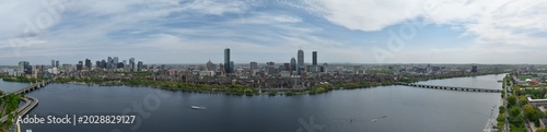 Panoramic aerial drone view of Boston Back Bay skyline, Prudential Tower, and Charles River Esplanade on a clear summer day, featuring historic brownstones and city skyscrapers, USA.