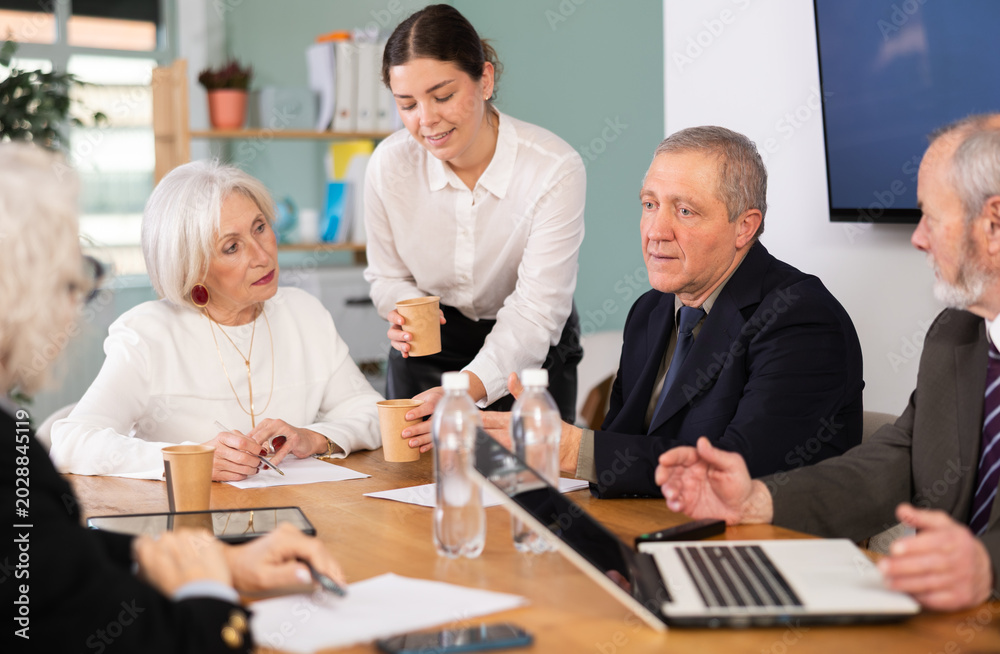 © JackF - Elderly businessman holds meeting with male and female colleagues in office