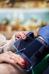 Close up of elderly people adjusting tight cuff for blood pressure monitoring, daily care routine. Electronic BP monitor with gauge and pump, ensuring longevity and wellness during retirement.