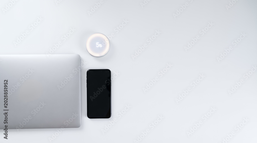 Fototapeta premium Top view of laptop smartphone and smart device with discount price tag 5 percent off display on white office desk. Promotional offer rebate e-commerce marketing. Special sale promotion with copy-space
