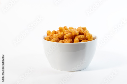 A white ceramic cup with crunchy peanut flips snacks isolated on a clean white background