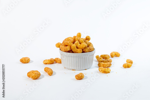 A white ceramic cup with crunchy peanut flips snacks isolated on a clean white background