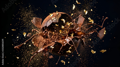 Luxury Chocolate Dessert Explosion with Gold Flakes and Splashing Melted Dark Chocolate on Black Background, Premium Gourmet Sweet Concept, High Speed Freeze Motion Food Art