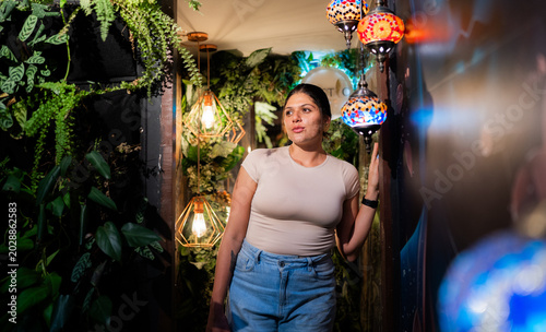 Foto Mujer joven posando en un interior tropical con luces decorativas y ambiente aco