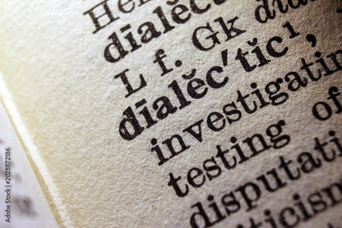 Word dialectic on dictionary page, macro close up