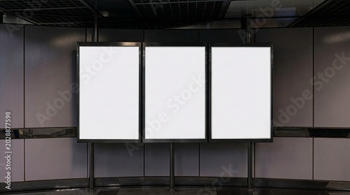 Quadro su tela A set of three empty vertical poster mockups displayed in a modern underground subway station corridor