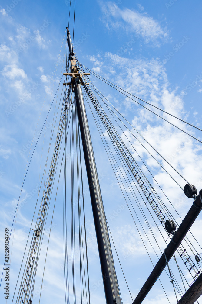 Obraz premium Sailboat Mast and ropes with cloudy blue sky background