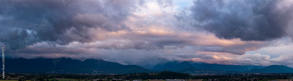 Obraz premium Dramatic Storm Clouds Over Chilliwack Mountains at Sunset Panorama in British Columbia, Canada
