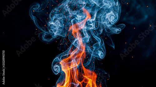 Obraz na płótnie Vertical column of dynamic orange flames transitioning into ethereal grey smoke against a stark black background