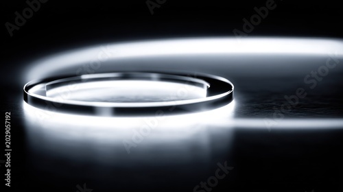 Glowing circular object emits bright white light against a dark background