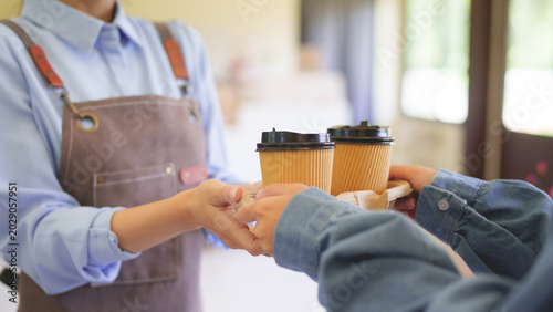 Photos Asian barista serving takeaway coffee customer at cafe counter worker handing ho