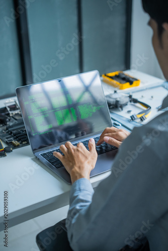 Asian IT engineer man using AI vibe coding on laptop