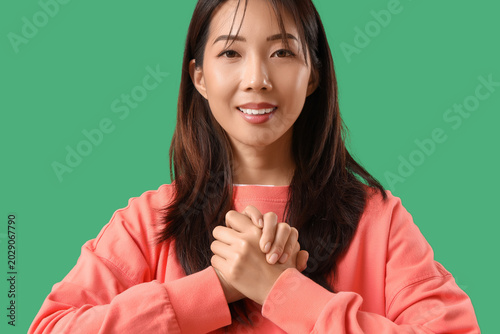 Young happy Asian woman usi...