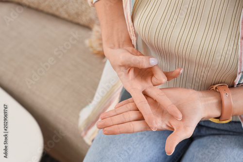 Young woman using sign language on sofa at home, closeup