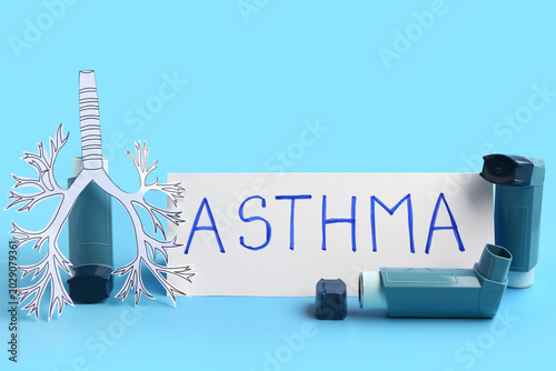Photos Inhalers, paper lungs and paper sheet with text ASTHMA on blue background