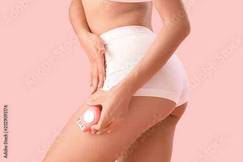 Canvastavla Beautiful young woman with epilator on pink background, closeup